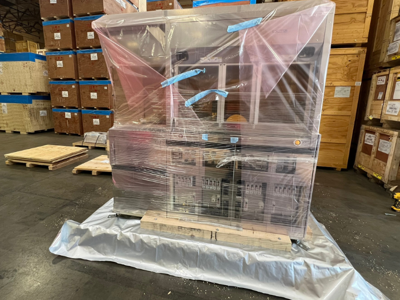 A semiconductor being carefully wrapped in protective plastic, preparing it for custom crating to ensure safe transportation.