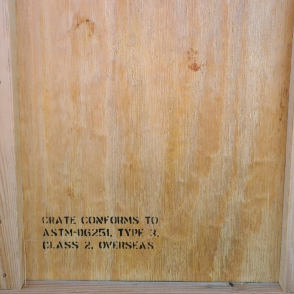 Close-up of MIL-SPEC code stamped on wood: 'Crate conforms to ASTM-D6251 Type 2, Class 2, Overseas.