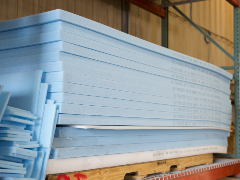 Stacks of raw foam sheets awaiting customization for use in protective crating solutions