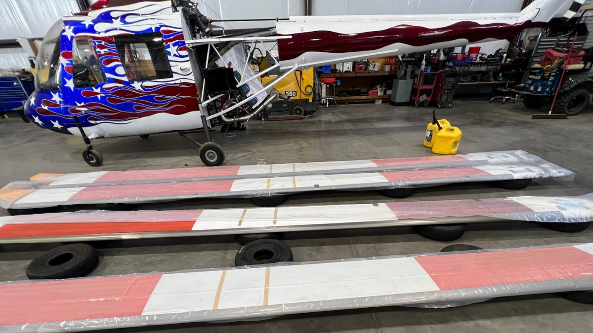 Helicopter rotor blades laid on the floor being prepped for custom crating to ensure safe transportation.