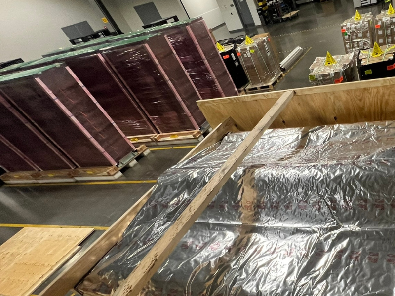 A data center server rack being securely crated for relocation, with protective packaging and shock-absorbing materials