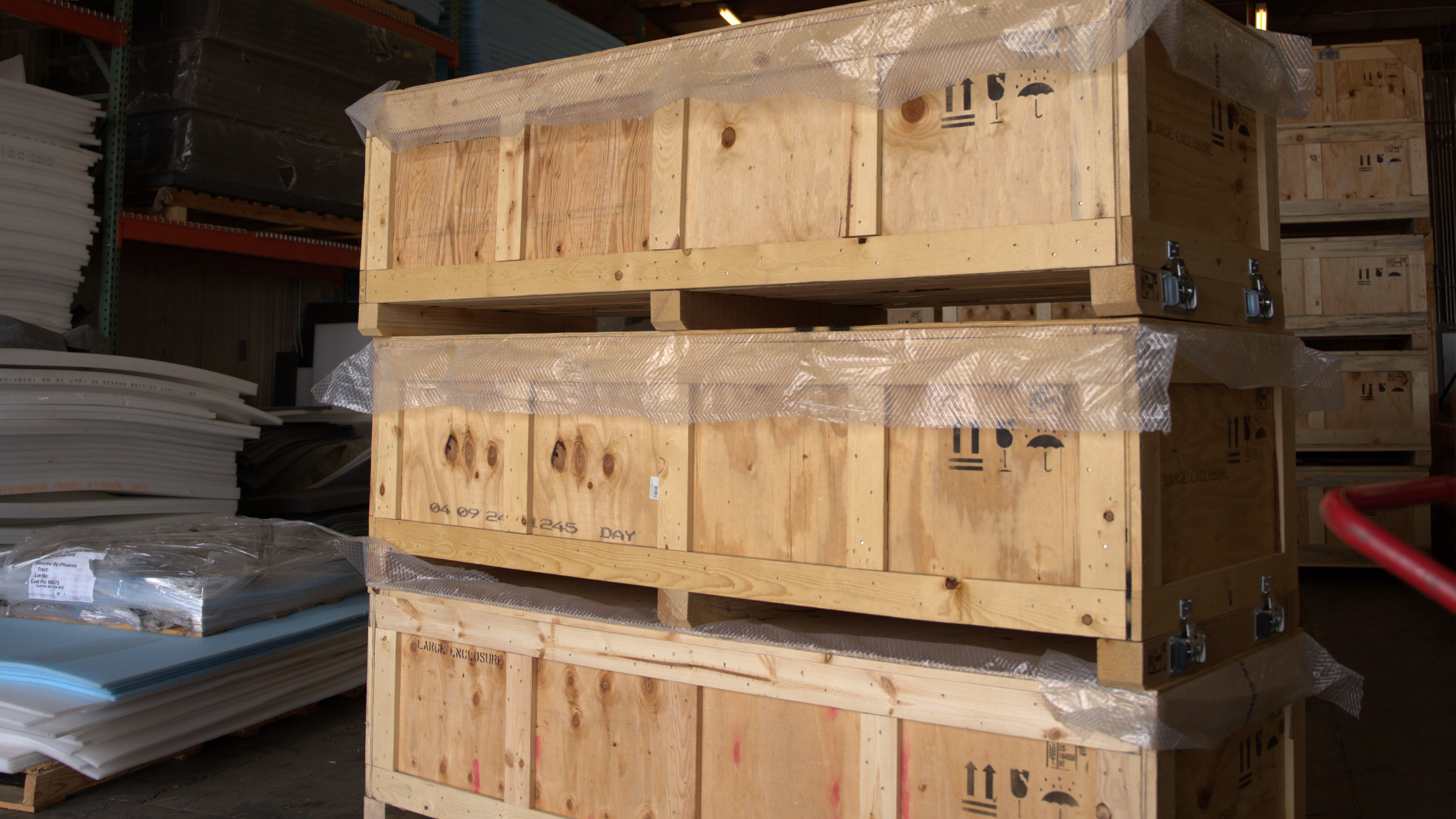 Three heavy-duty wooden crates stacked securely in a warehouse setting, illustrating a restack workflow designed for safe storage and efficient freight handling.