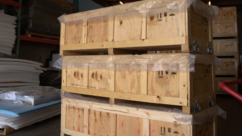 Three custom-built wooden shipping crates stacked securely on top of each other, demonstrating efficient use of space for warehouse storage or freight consolidation