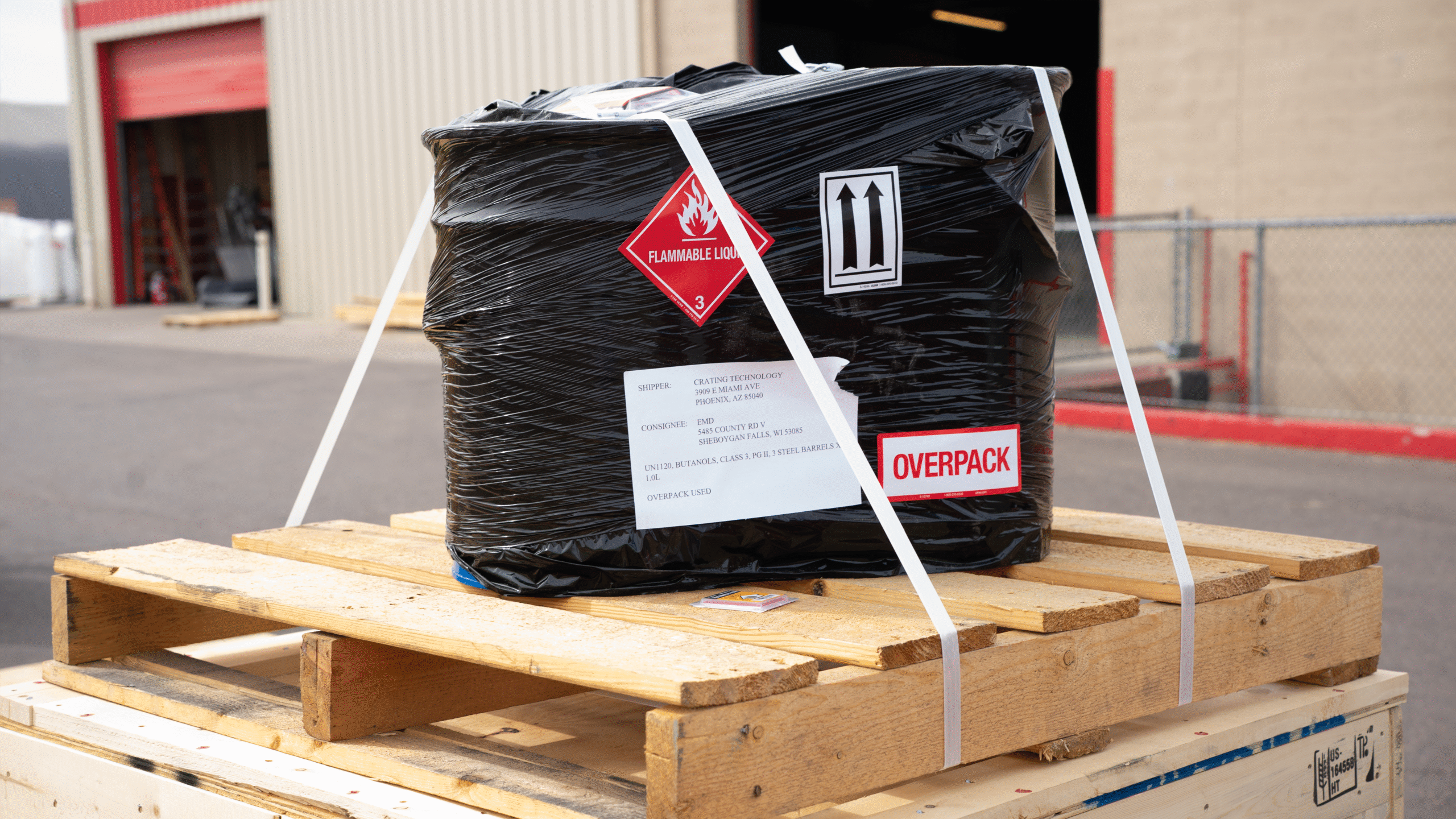 Hazardous liquid containers banded and secured on a pallet, prepared for safe and compliant shipment.