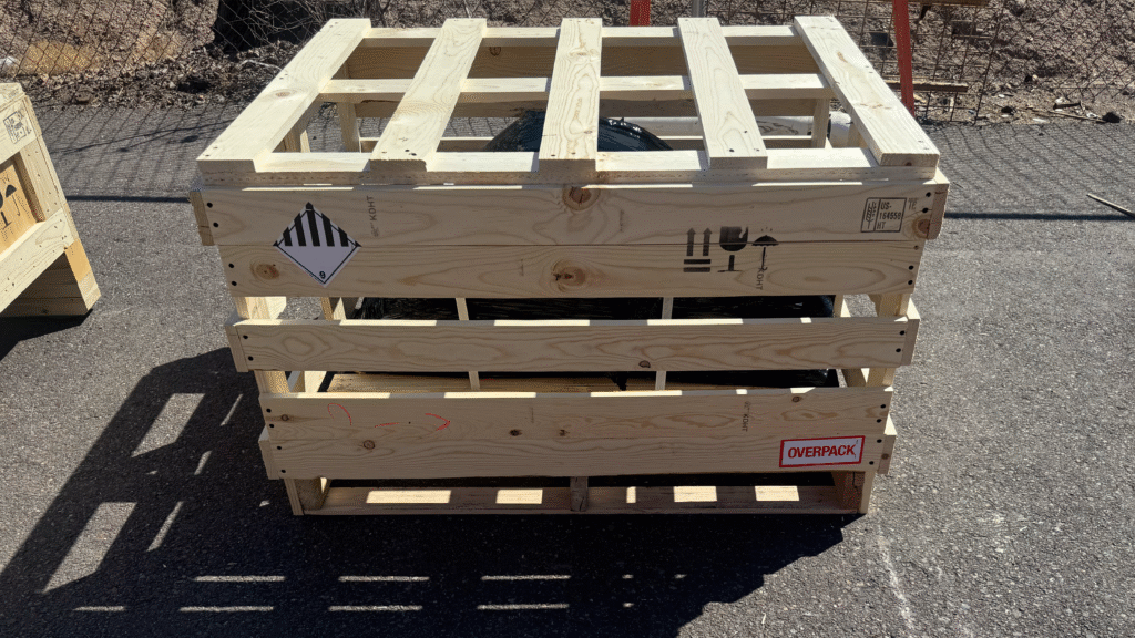 Hazardous material being crated in an open wood frame to ensure airflow and permit safe off-gassing during storage and transport.