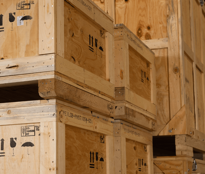 Stack of wooden crates featuring the ISPM-15 stamp, signifying compliance with international shipping standards for treated wood packaging