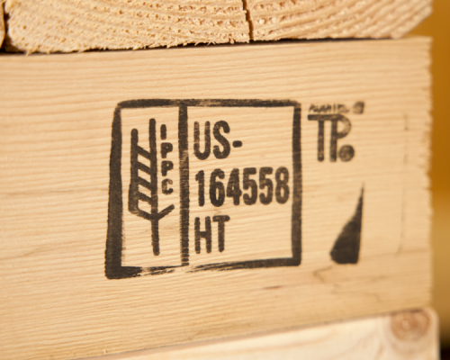 Close-up of the ISPM-15 stamp on a wooden crate, showcasing compliance with international shipping regulations for treated wood packaging